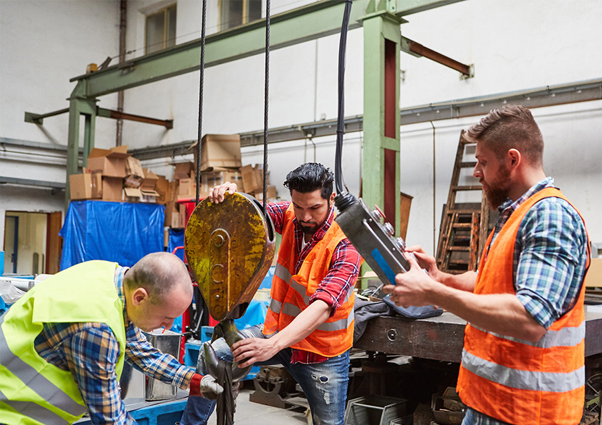 Kran Bedienung durch Mitarbeiter Mitarbeiter bedienen in einer Produktionshalle einen Kran