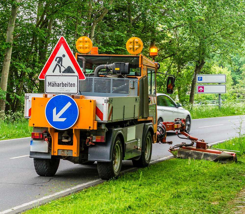 Fahrzeug der Straßenwartung bei Mäharbeiten