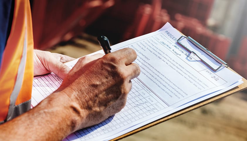 Mann in Warnweste mit Klemmbrett