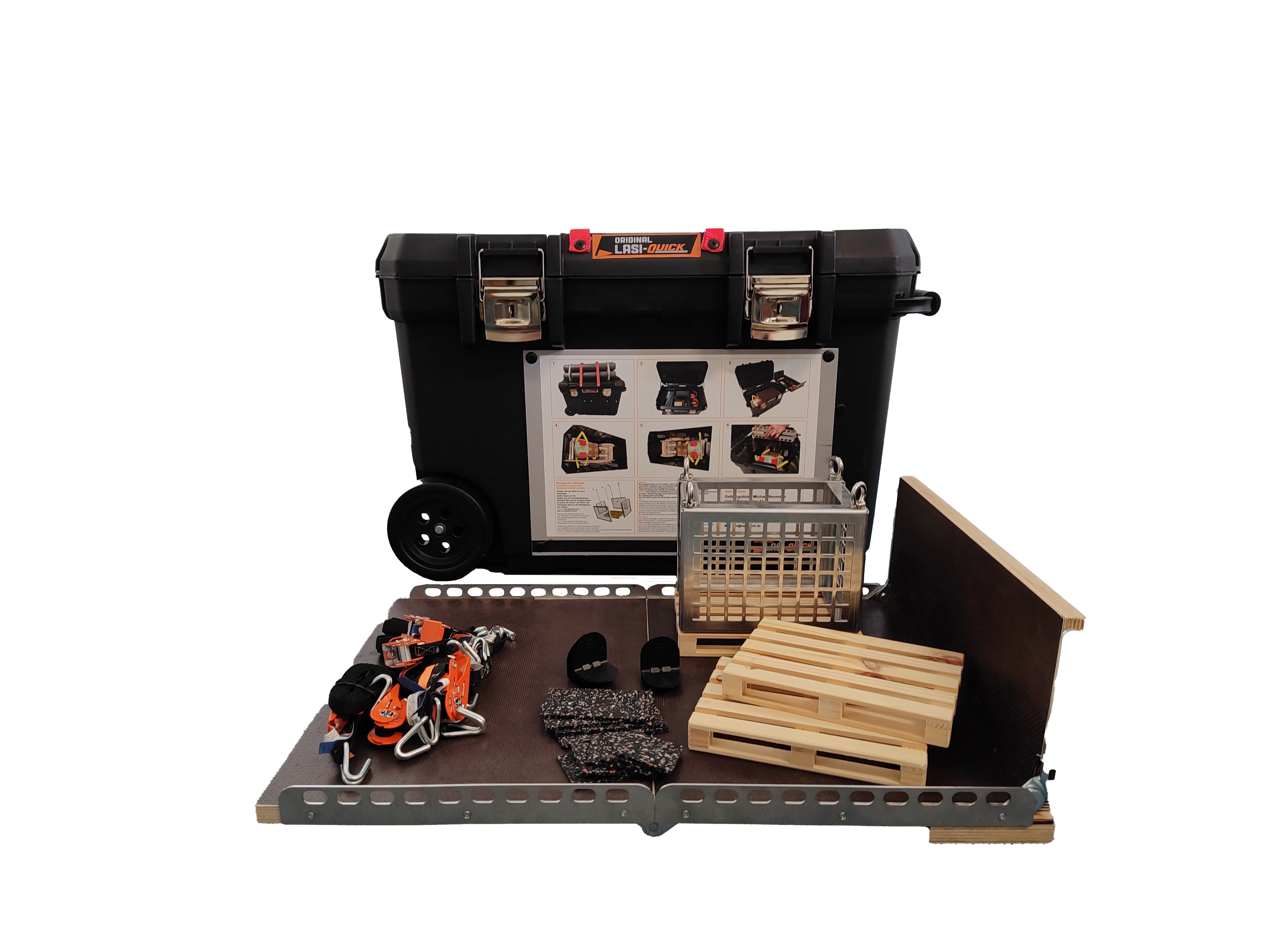 Eine Gitterbox, Zurrgurte, Anti-Rutschmatten, Kantenschoner und zwei Palletten stehen auf einer klappbaren Ladefläche, welche vor einem schwarzen Trolley liegen.