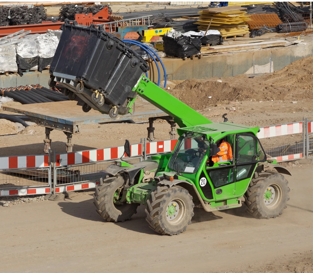 Grüner Teleskoplader transportiert Behälter