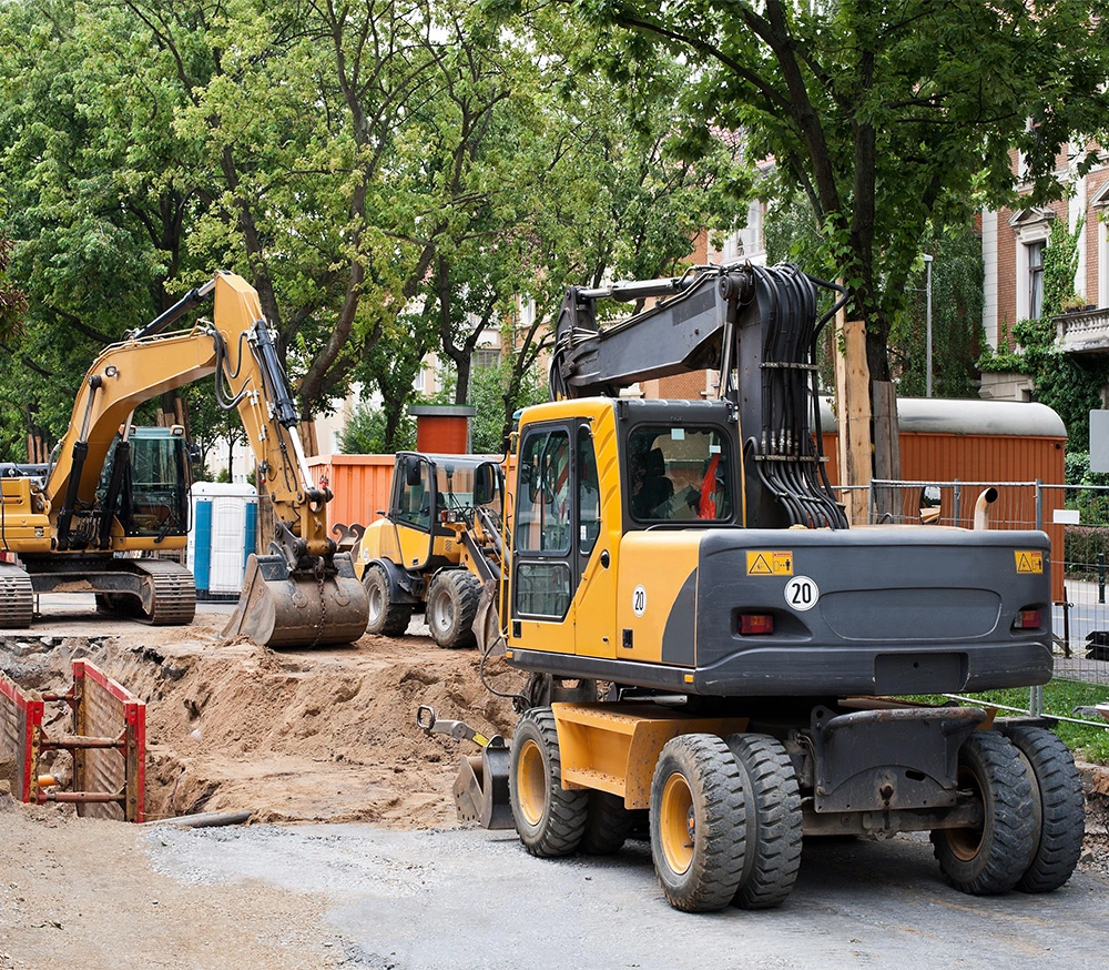 Baustelle mit Bagger neben Bäumen