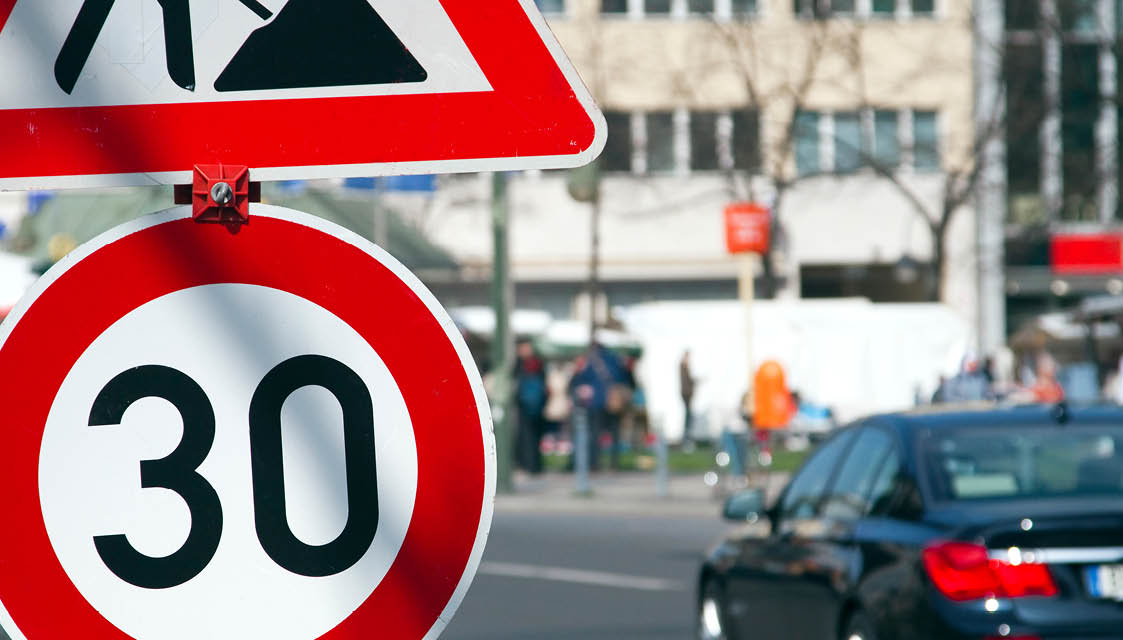 Reform des Straßenverkehrsgesetzes: Mehr Klimaschutz und lokale Flexibilität Schilder "Bauarbeiten" und "Geschwindigkeitsbegrenzung 30" an befahrener Straße