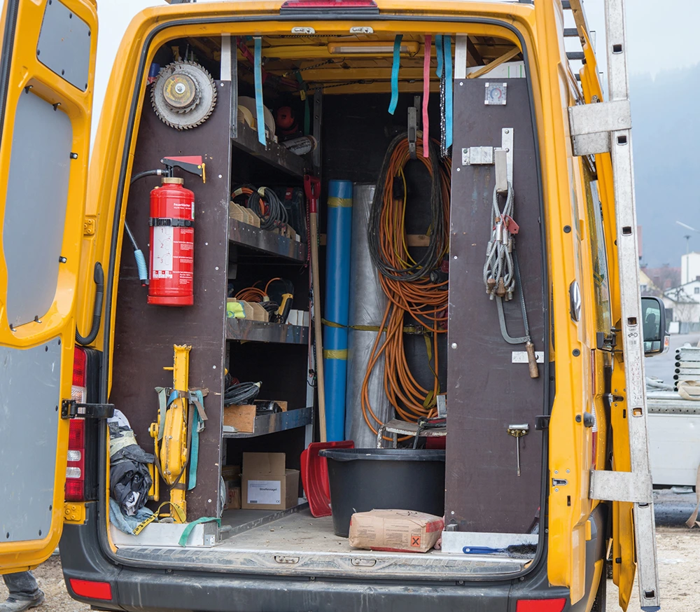  Gelber Transporter, der mit verschiedenen Werkzeugen gefüllt ist, ideal für Bau- und Reparaturprojekte.