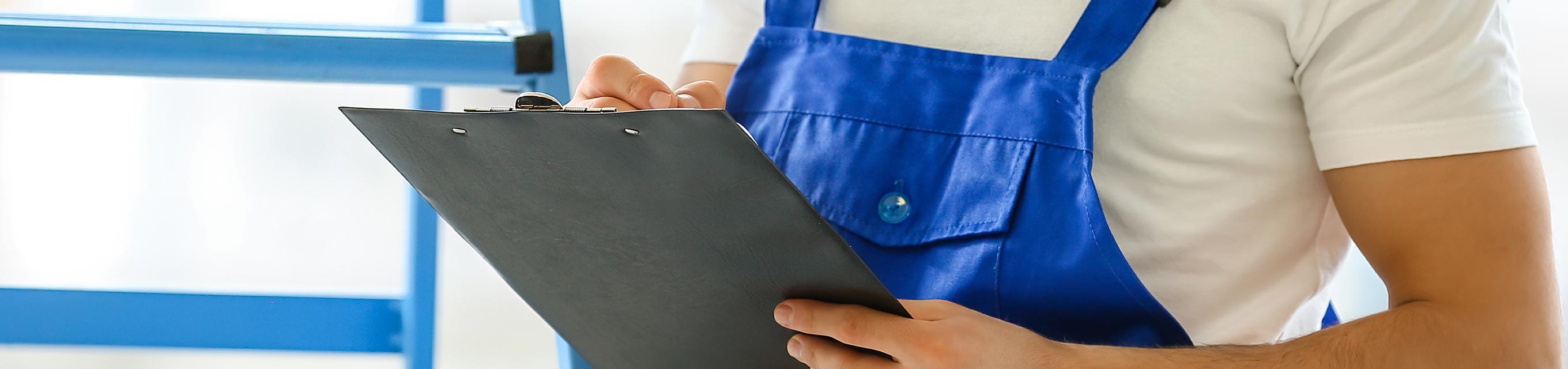 Mann im Blaumann mit Klemmbrett